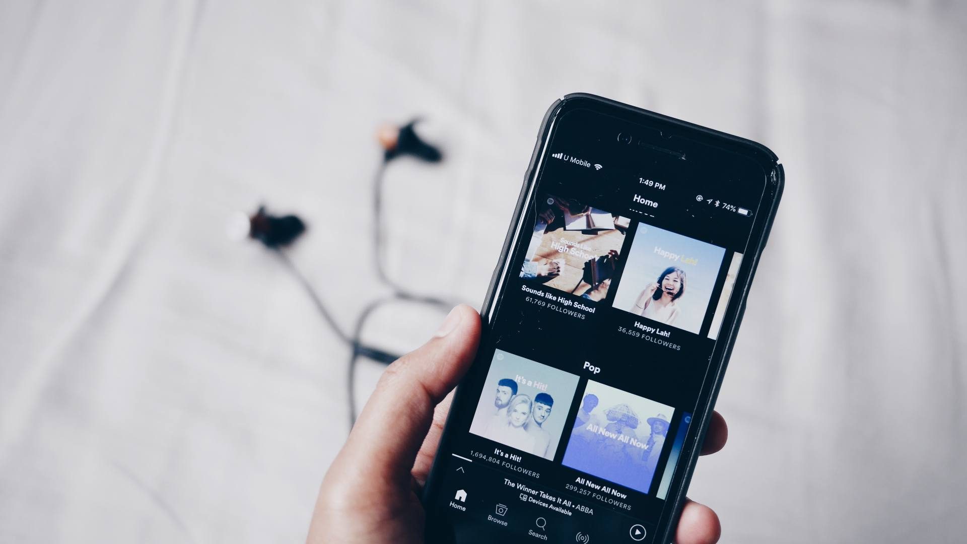 Spotify playlists on a mobile phone with headphones